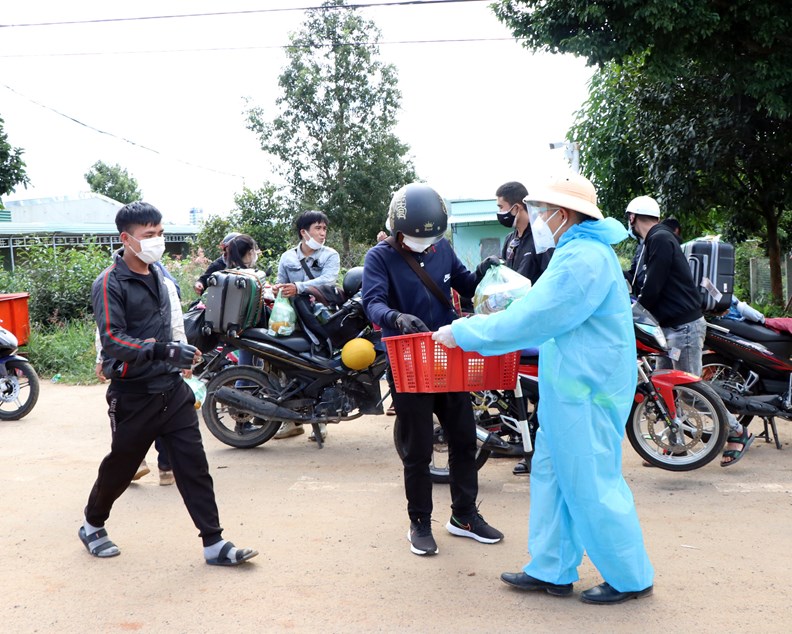 Các lực lượng chức năng hỗ trợ người dân từ các tỉnh phía Nam về quê qua chốt kiểm dịch y tế giữa Gia Lai và Kon Tum. - Ảnh: VGP